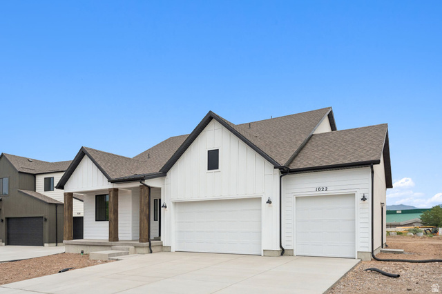 1004 West Paramount Cove South, Unit 315 Ogden, UT 84405 - Photo 4 of 42 Modern farmhouse exterior featuring white board and batten siding, dark trim accents, and a covered porch with wood wrapped columns