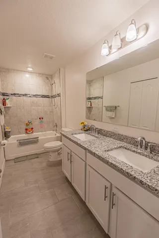 a spacious bathroom with a granite countertop sink mirror and bathtub