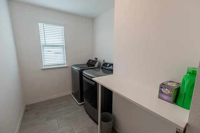a utility room with fridge and washer