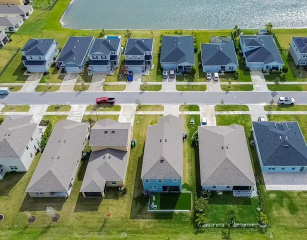 an aerial view of residential houses with outdoor space and parking