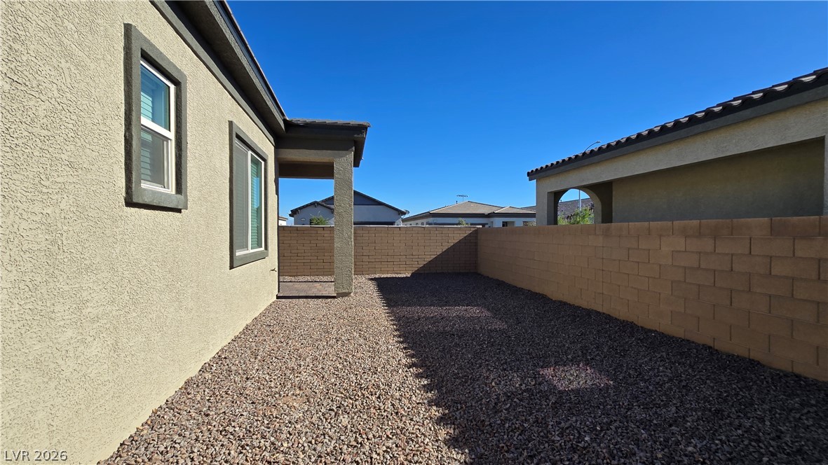 852 Weston Ridge Street Henderson, NV 89011 - Photo 27 of 28 A low-maintenance yard offers privacy and a clear view of the vibrant blue sky.