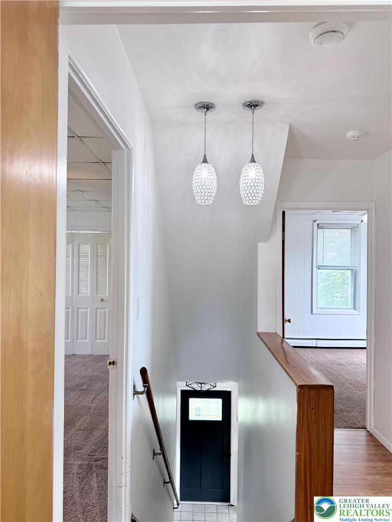 5540 Main Street Whitehall, PA 18052 - Photo 21 of 53 Illuminated by chic pendant lights, this staircase descends to a tiled landing and a dark entry door.