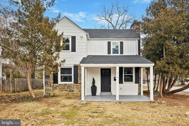 a view of a white house with a large windows and large tree
