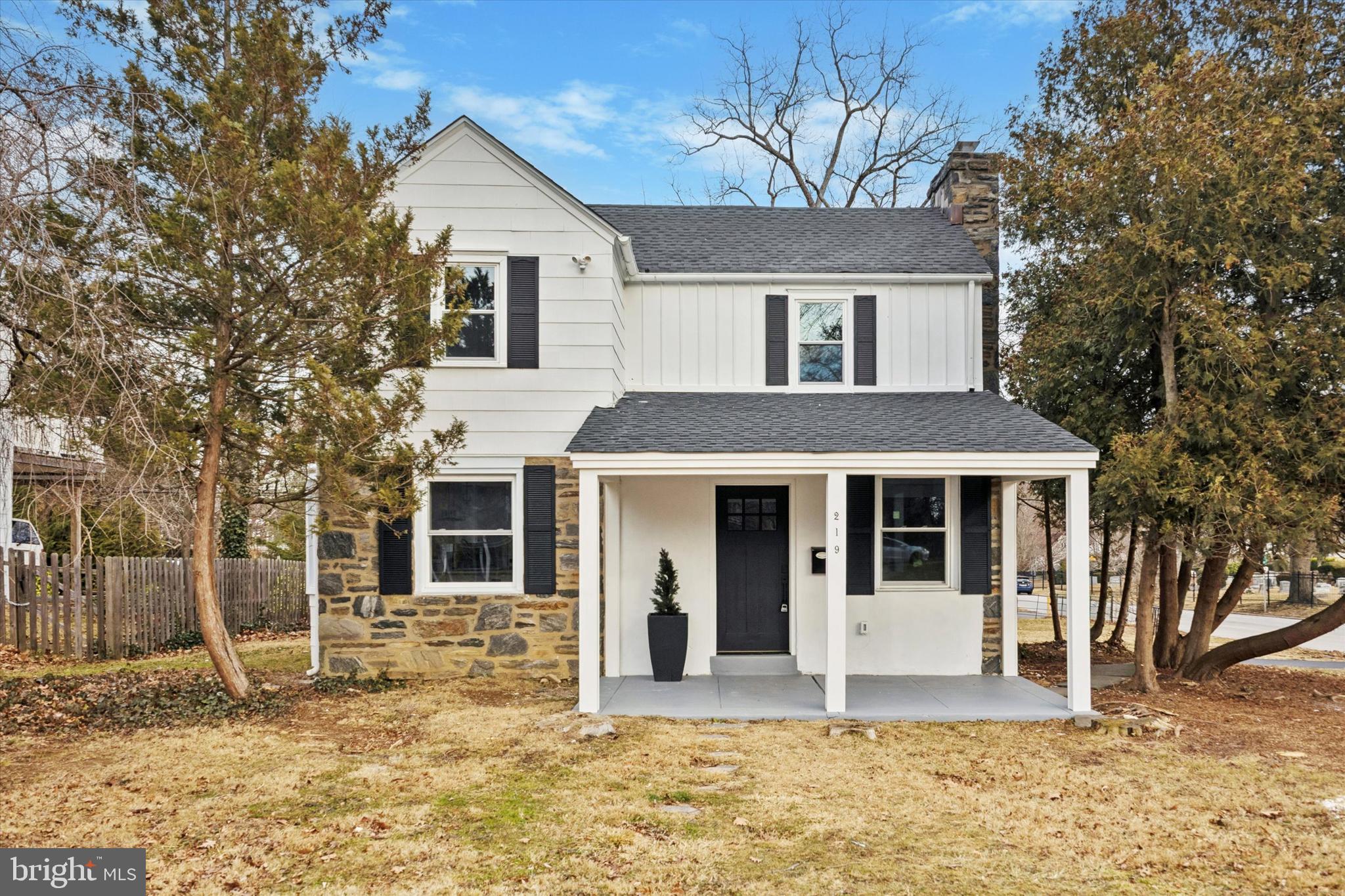 a view of a white house with a large windows and large tree