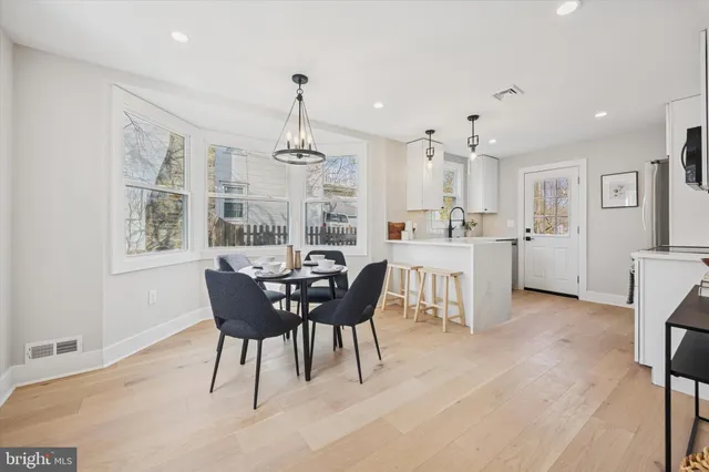 a dining room with furniture a chandelier and wooden floor