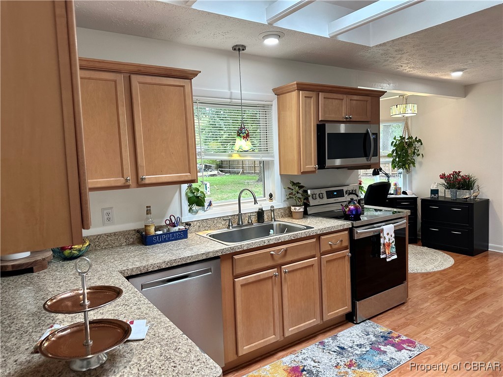 7809 Ark Road Gloucester, VA 23061 - Photo 6 of 32 Kitchen featuring sink, pendant lighting, light hardwood / wood-style floors, a textured ceiling, and appliances with stainless steel finishes