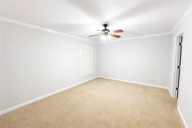 an empty room with a window and a ceiling fan