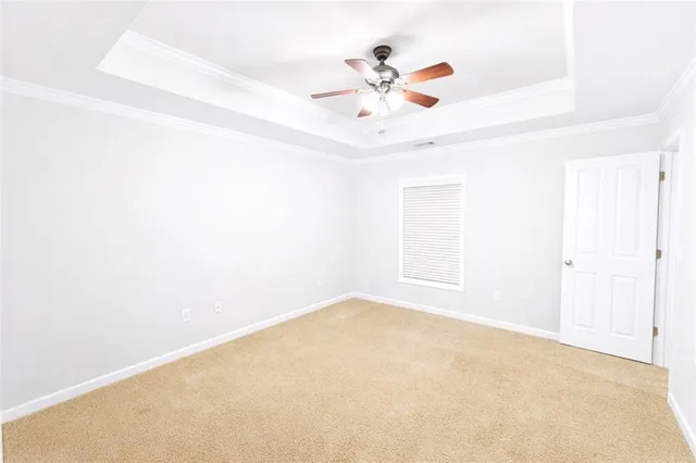 an empty room with a chandelier fan and closet