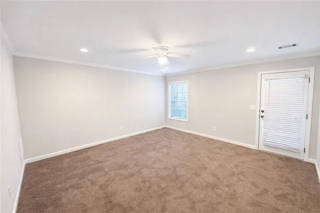 an empty room with an entryway and fan