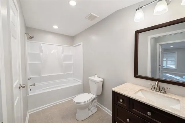 a bathroom with a granite countertop sink toilet a mirror and shower