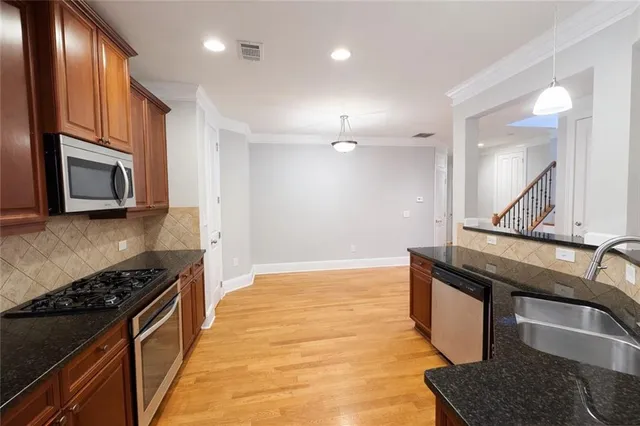 a kitchen with stainless steel appliances granite countertop a sink and a stove