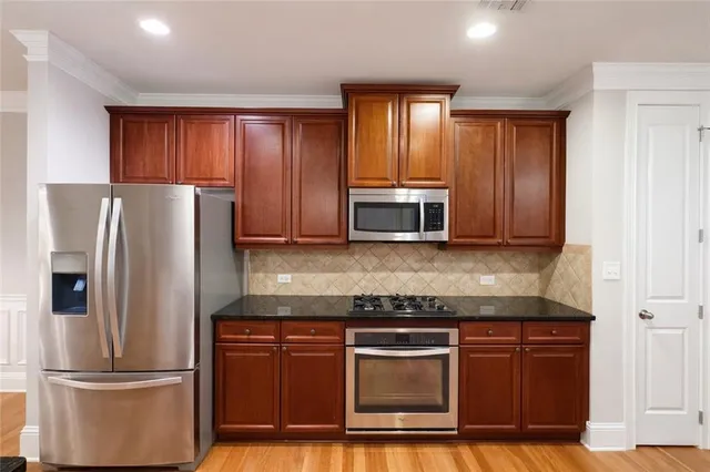 a kitchen with granite countertop stainless steel appliances and wooden cabinets