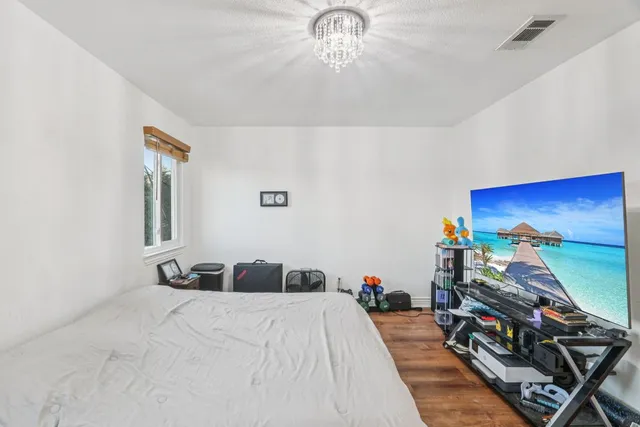a bedroom with a bed and a chandelier