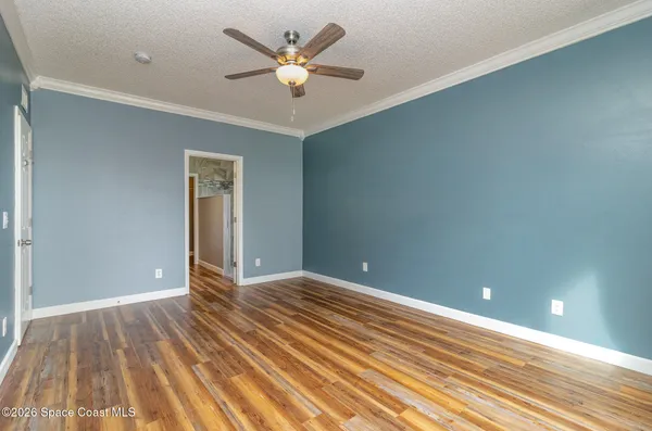 a view of an empty room with wooden floor