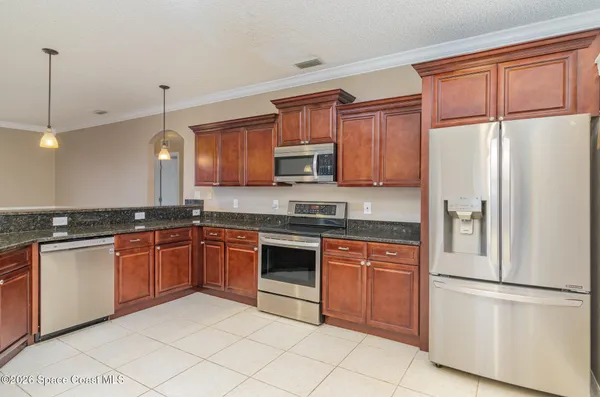a kitchen with granite countertop stainless steel appliances and wooden cabinets