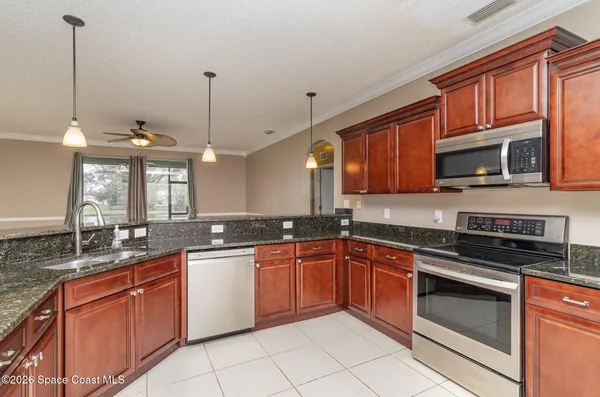 a kitchen with stainless steel appliances granite countertop wooden cabinets stove a sink and dishwasher