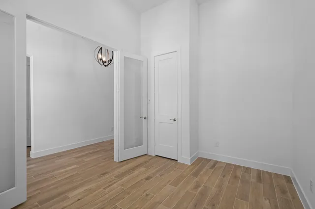 a view of an empty room with wooden floor