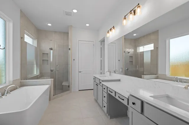 a bathroom with a granite countertop double vanity sink large mirror bathtub and shower