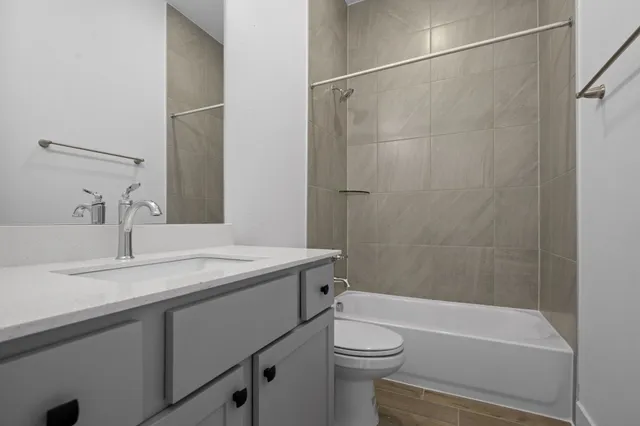 a bathroom with a granite countertop sink toilet and shower