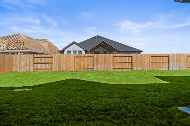 a view of a big house with a big yard and large trees