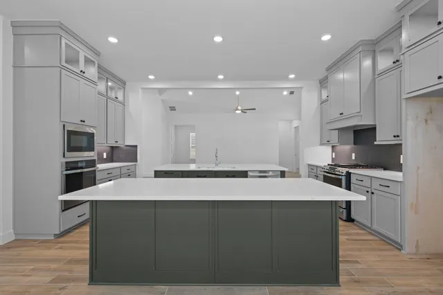 a large kitchen with kitchen island a sink stainless steel appliances and cabinets