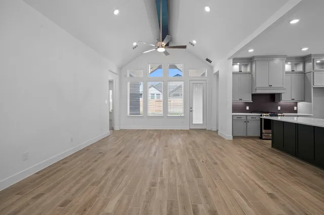 a view of kitchen with kitchen island wooden floor and refrigerator