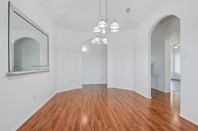 a view of a room with wooden floor and chandelier