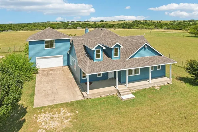 an aerial view of a house with a garden and lake view