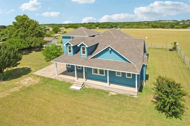 an aerial view of a house with a garden and lake view