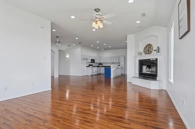 a view of a livingroom with a fireplace a chandelier and wooden floor