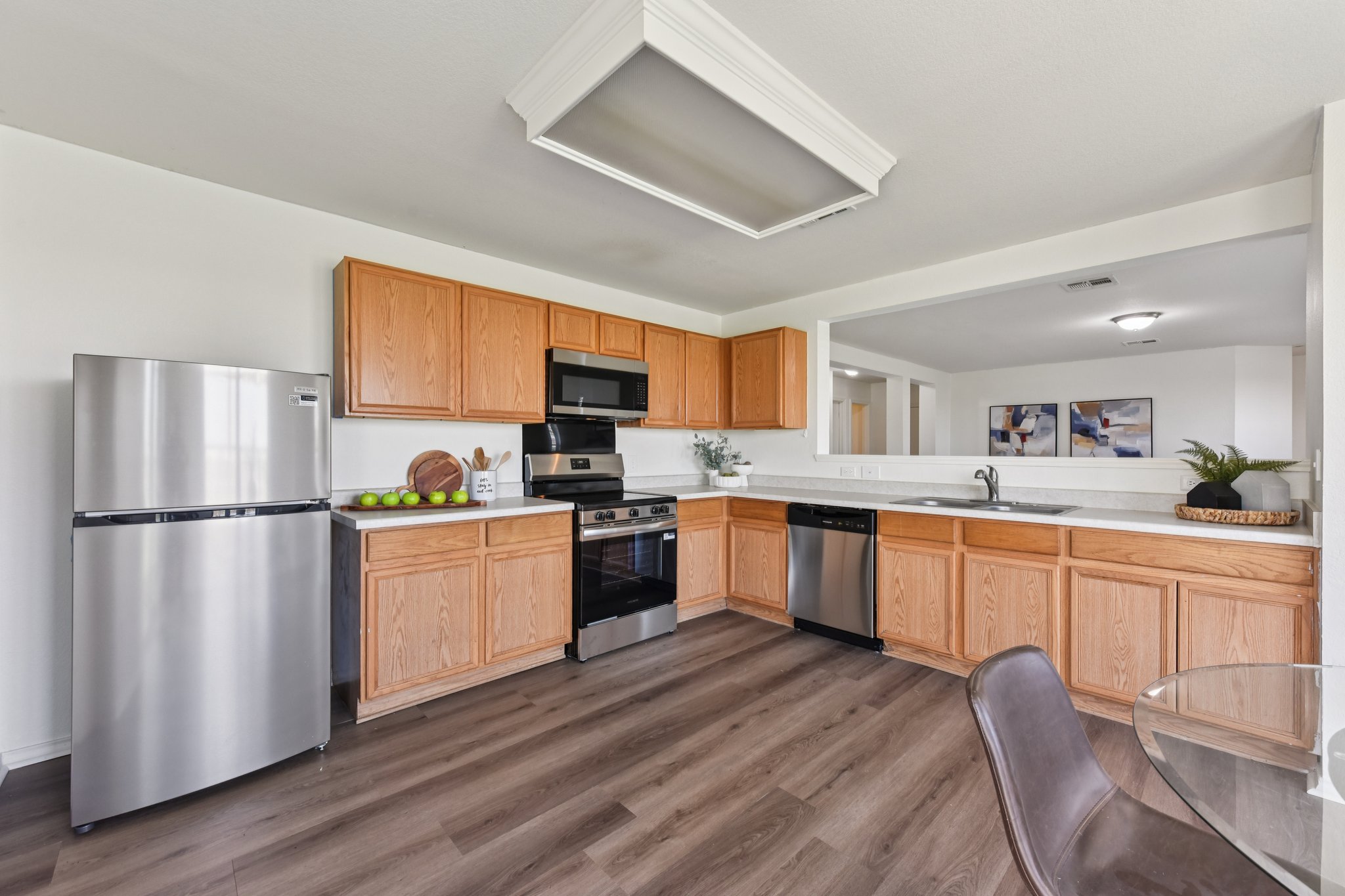 101 Bandara Woods Boulevard Elgin, TX 78621 - Photo 12 of 30 Kitchen featuring stainless steel appliances, light countertops, dark wood finished floors, and light wood finish cabinets
