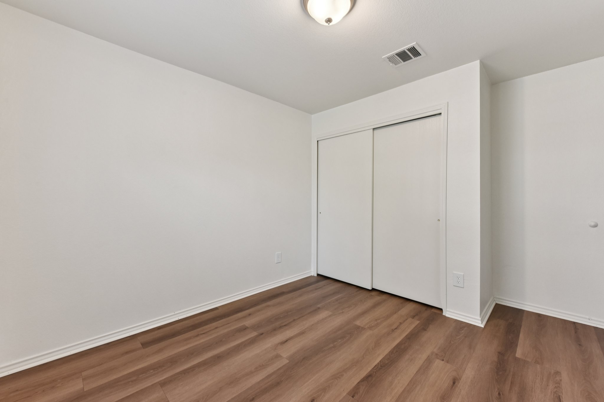 101 Bandara Woods Boulevard Elgin, TX 78621 - Photo 18 of 30 Unfurnished bedroom featuring dark wood-type flooring and a closet