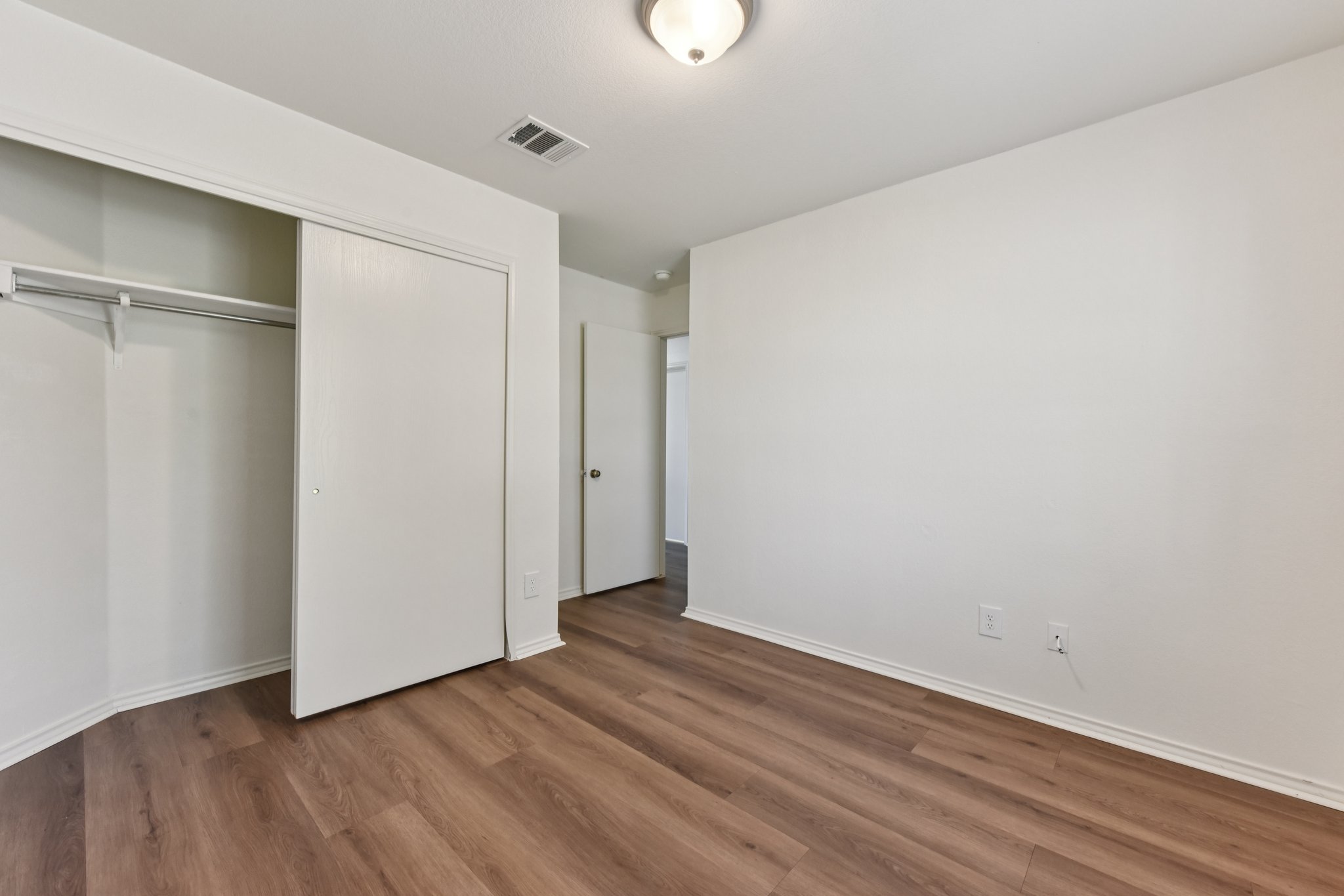 101 Bandara Woods Boulevard Elgin, TX 78621 - Photo 19 of 30 Unfurnished bedroom featuring a closet and dark wood-style flooring