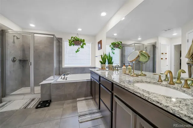 a bathroom with a double vanity sink mirror and bathtub