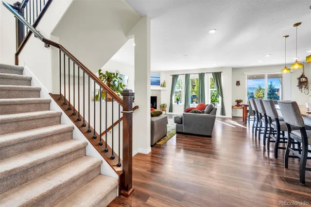 a living room with furniture and a dining table with wooden floor
