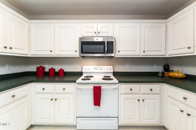 a kitchen with white cabinets and white appliances