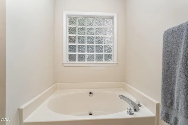a white bath tub sitting in a bathroom next to a window