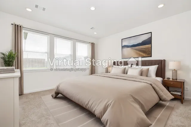 a bedroom with a bed and a large window