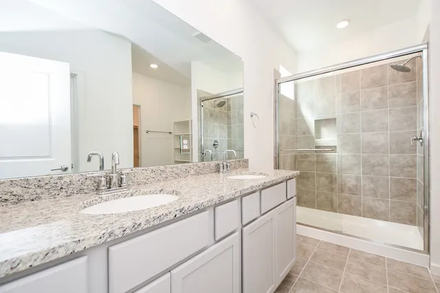 a bathroom with a granite countertop sink a shower and a mirror