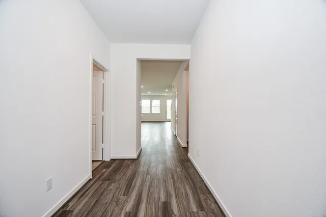 a view of a hallway with wooden floor