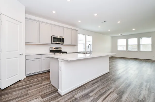 a kitchen with granite countertop white cabinets and white appliances