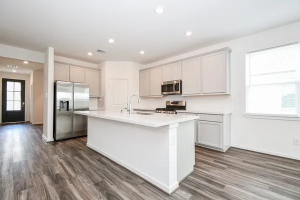 a kitchen with cabinets and wooden floor