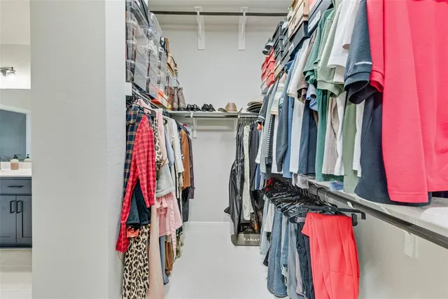 a view of walk in closet with clothes