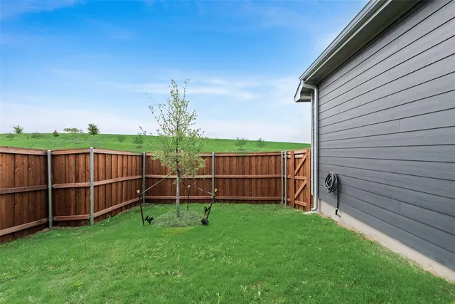 a view of a backyard with wooden fence