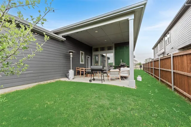 a view of a chair and table in backyard of the house