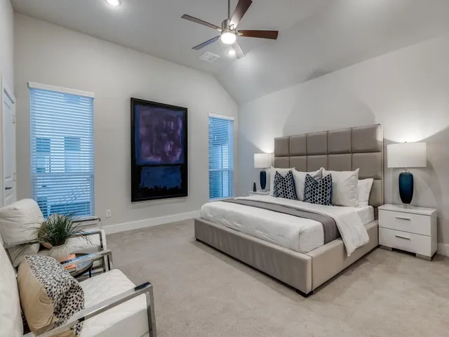 a spacious bedroom with a bed and ceiling fan