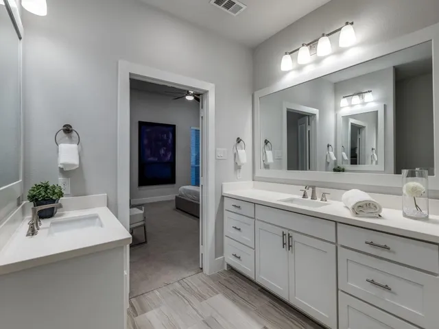 a spacious en suite bathroom with double sink and a mirror