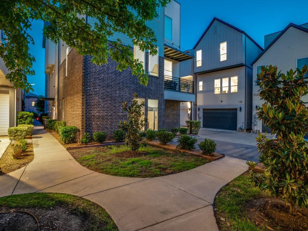 1129 Manderly Court Dallas, TX 75204 - Photo 27 of 33 Modern home featuring a balcony, board and batten siding, brick siding, and driveway