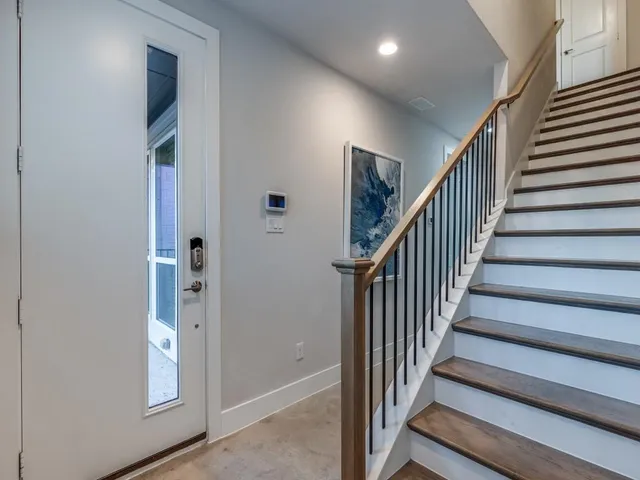 a view of staircase with lots of frames on wall and stairs