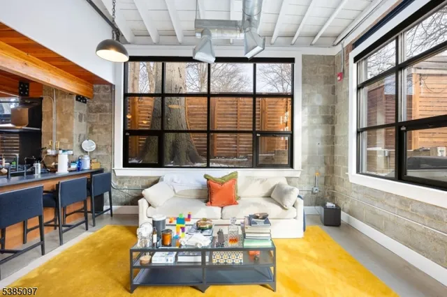 a living room filled with furniture and large windows
